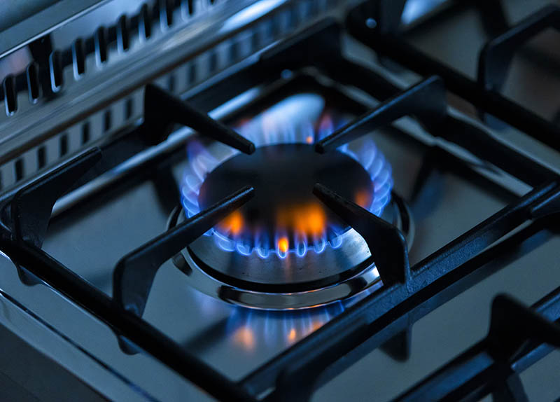 kitchen gas stove alight with flame coming out of it. Conceptual photo for gas, cost of bills, rising prices, heat and the environment. metal Ukraine, Russia, Europe. blu flame. united states. cook